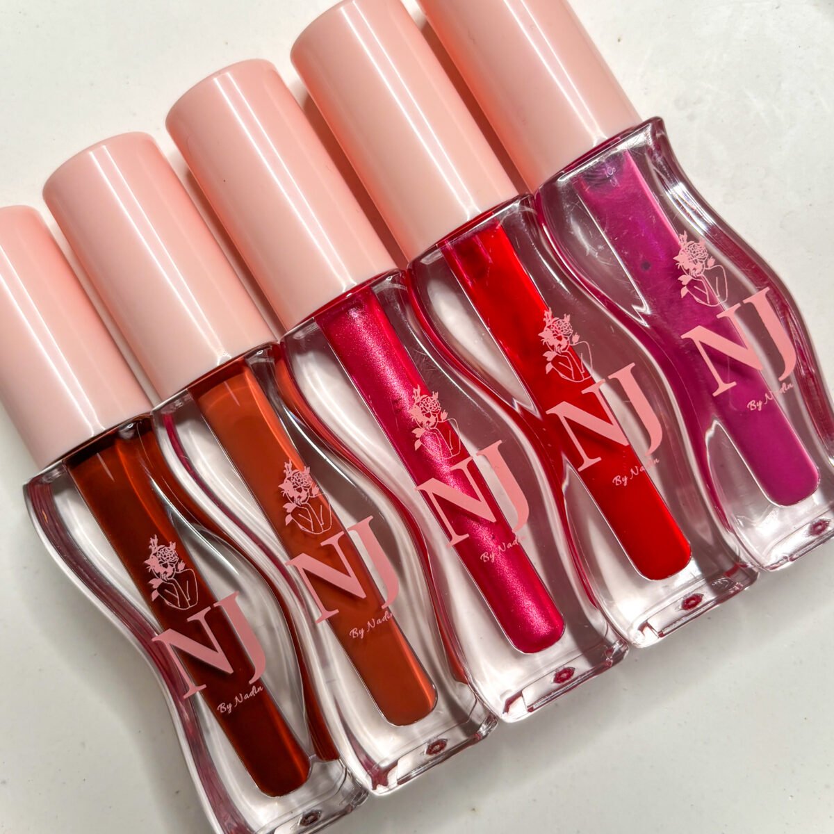 NJ LipGloss – Bold color meets creamy shine. Highly pigmented, ultra-moisturizing, and 100% vegan. قلوس NJ – لون جريء ولمعان كريمي. تركيبة مرطّبة غنيّة بالأصباغ ونباتية 100٪.
